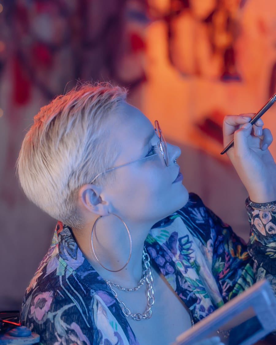 Artist working on a client under warm studio lighting